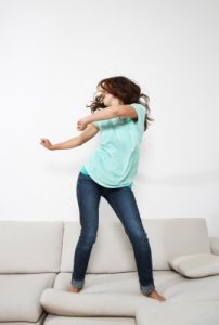 Bild: Frau tanzt auf Couch