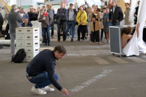 Bild: Strichwörter live auf Asphalt geschrieben