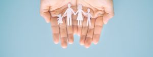 Bild: Hände halten ausgeschnittene Papierfamilie