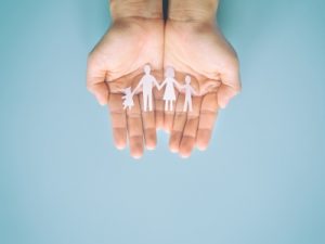 Bild: Hände halten ausgeschnitte Papier-Familie